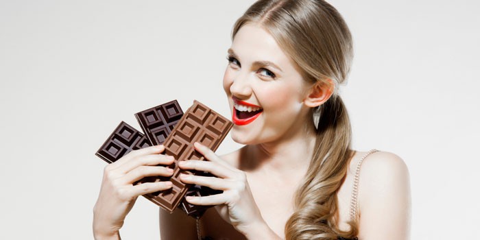 Девушка с плитками шоколада в руках