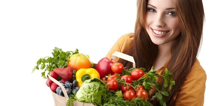 Девушка держит пакет с овощами и фруктами