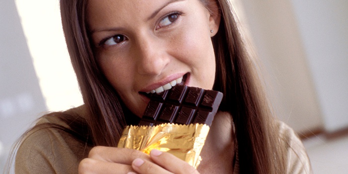 Девушка ест горький шоколад для похудения