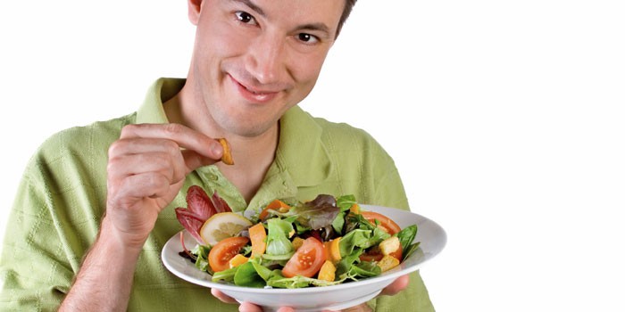 Мужчина держит в руках тарелку с салатом